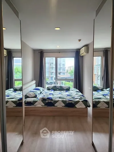 Modern bedroom with large mirrors and city view, featuring stylish decor and ample natural light.