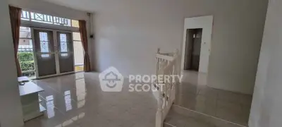 Spacious living room with tiled flooring and large windows for natural light.
