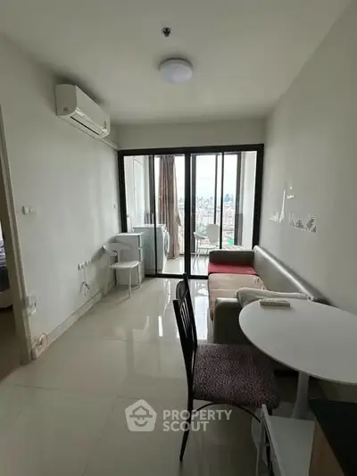 Modern living room with balcony view, featuring sleek furniture and natural light.