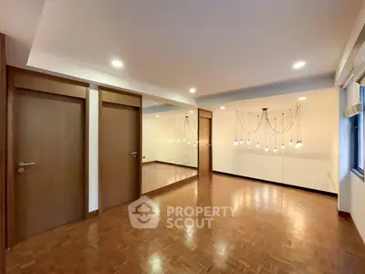 Spacious room with elegant lighting and wooden flooring, perfect for versatile living space.