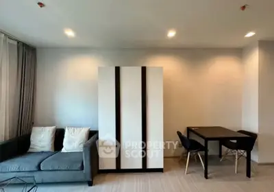 Modern living room with sleek furniture and minimalist design, featuring a cozy sofa and dining area.