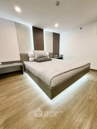 Modern bedroom with stylish bed and ambient lighting in a contemporary apartment.