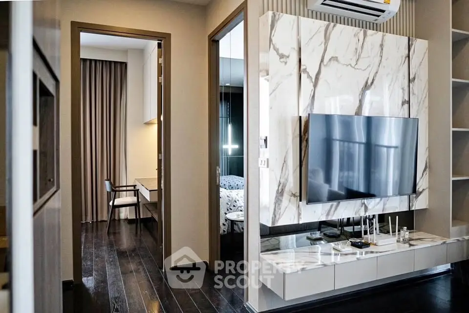 Modern living room with marble TV wall and dark wood flooring