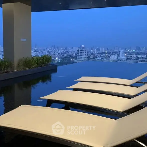 Luxurious rooftop pool with stunning city skyline view at dusk.