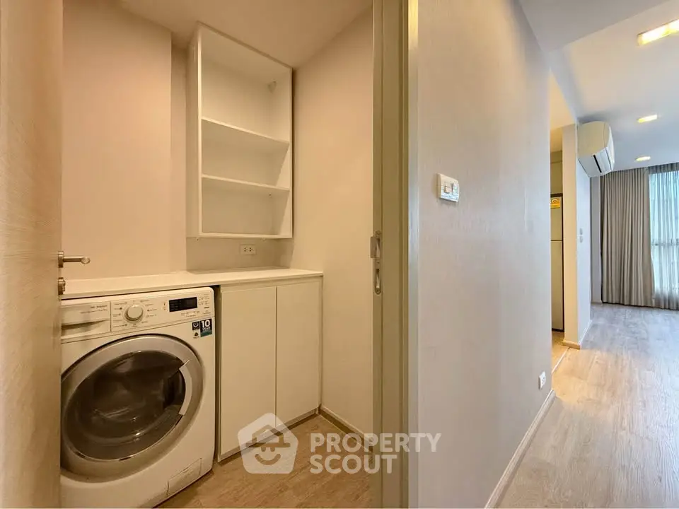 Modern apartment hallway with washing machine and storage cabinets