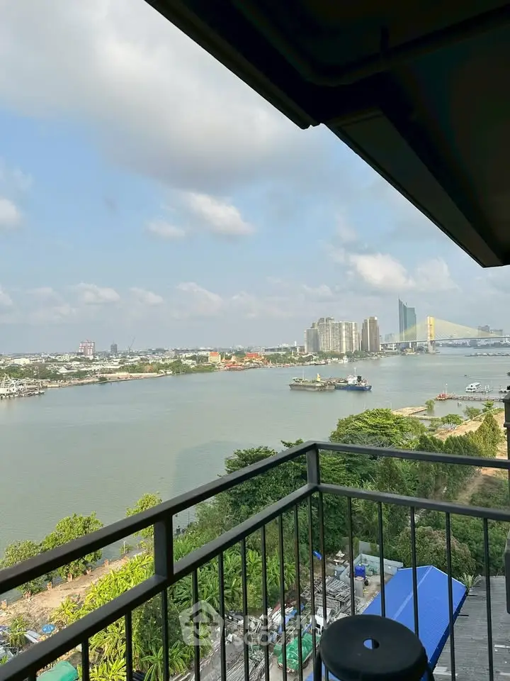 Stunning river view from a high-rise balcony overlooking the city skyline and lush greenery.
