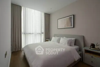 Elegant bedroom with modern decor and large window in a stylish apartment.