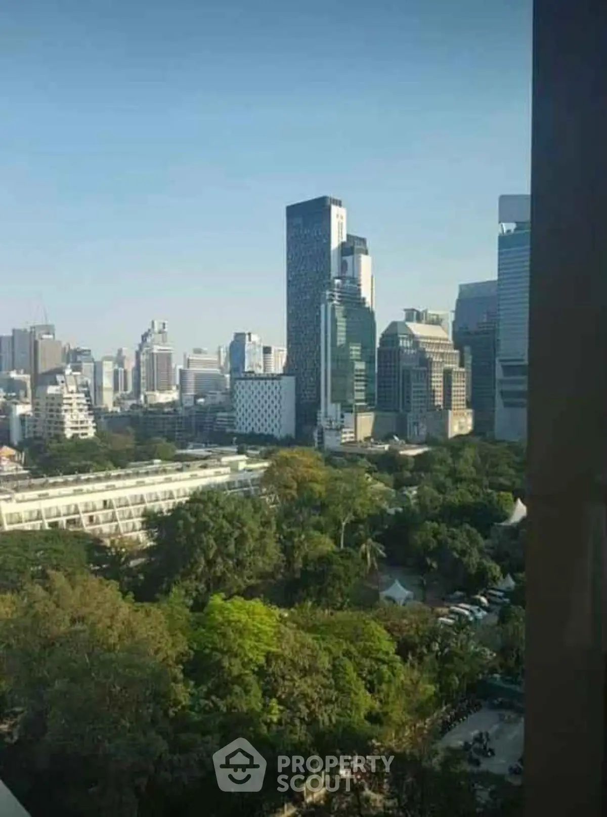 Stunning cityscape view with lush greenery and modern skyscrapers.