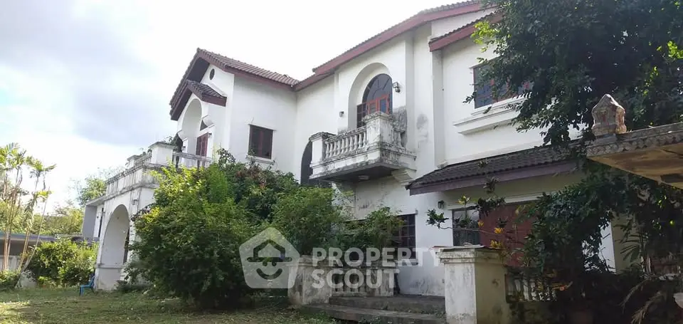 Stunning two-story villa with lush garden and classic architecture, perfect for luxurious living.
