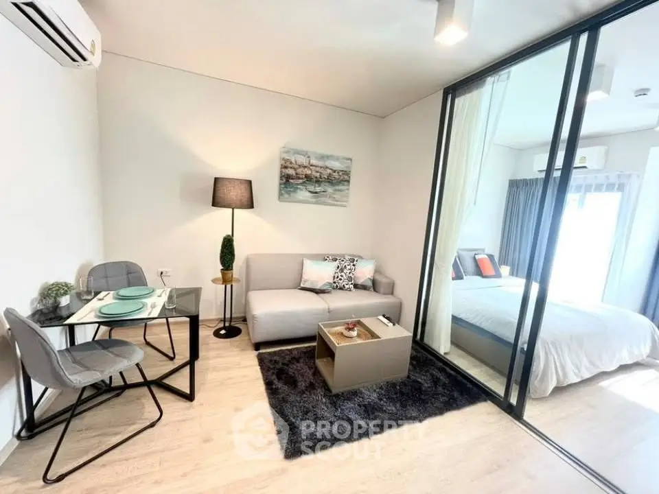 Modern living room with cozy seating and stylish decor adjacent to a bright bedroom.