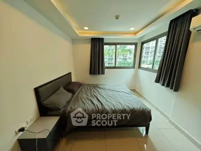 Modern bedroom with large windows and sleek design in urban apartment.