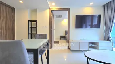 Modern living room with sleek furniture and wall-mounted TV in a bright apartment