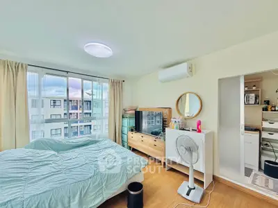 Bright and airy bedroom with large windows and modern furnishings in a stylish apartment.