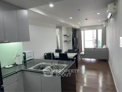 Modern open-layout kitchen and living room with sleek design and natural light.
