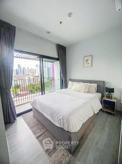 Modern bedroom with city view and balcony access in urban apartment