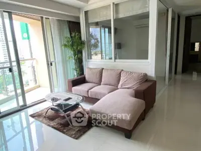 Spacious living room with modern decor and balcony view in urban apartment.