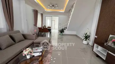 Modern living room with elegant decor and open layout, featuring a cozy sofa and stylish dining area.