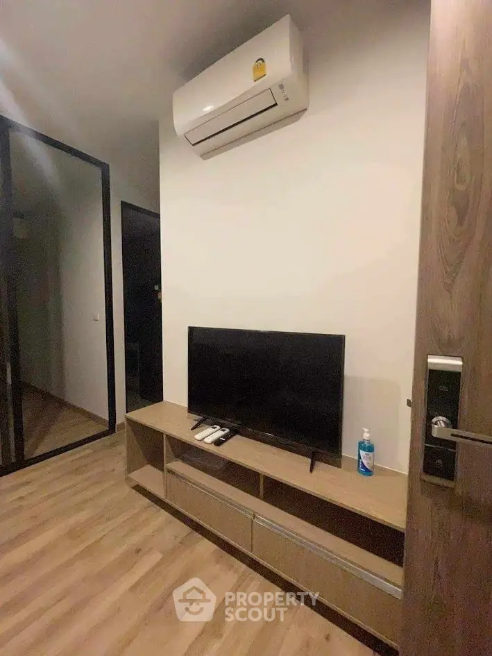 Modern living room with sleek TV setup and air conditioning unit