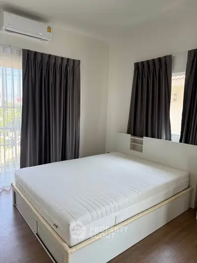 Modern bedroom with large windows and air conditioning, featuring a comfortable bed and elegant curtains.