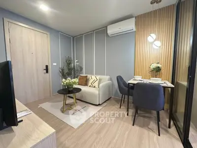 Modern living room with cozy seating and dining area, featuring stylish decor and air conditioning.