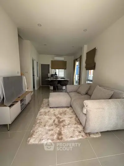 Spacious modern living room with plush sofa and open kitchen layout