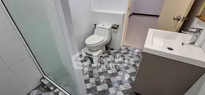 Modern bathroom with stylish tiles and sleek fixtures, featuring a shower and vanity.