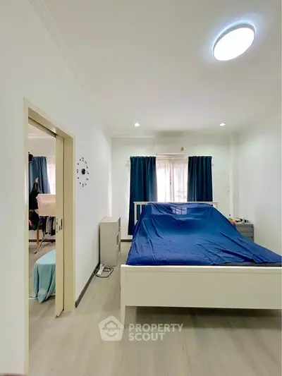 Spacious bedroom with modern decor and natural light, featuring a comfortable bed and stylish furnishings.