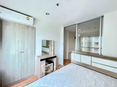 Modern bedroom with built-in wardrobe and air conditioning in a bright apartment.