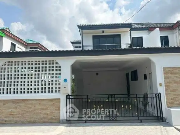 Modern two-story house with gated driveway and brick accents