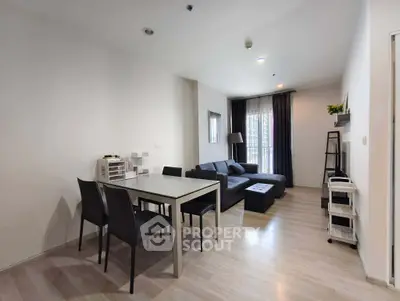 Modern living room with sleek furniture and dining area in open layout apartment.