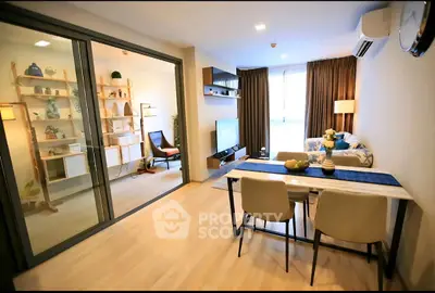 Modern living room with dining area and stylish decor, featuring a sliding glass door and natural light.