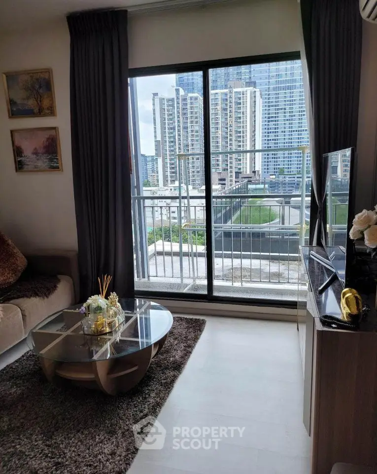 Modern living room with large window offering stunning city view, stylish decor, and cozy ambiance.