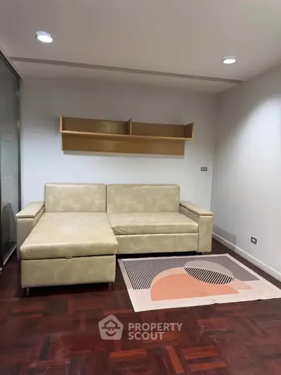 Modern living room with stylish beige sofa and wooden flooring, perfect for cozy relaxation.