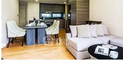 Modern living room with elegant dining area and cozy seating, featuring stylish decor and wooden flooring.