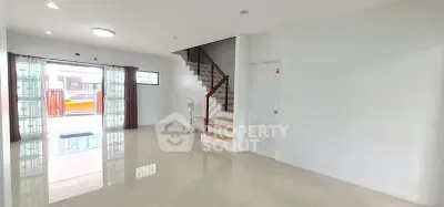 Spacious modern living room with staircase and large windows for natural light.