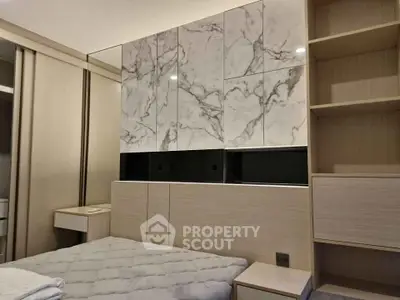 Modern bedroom with elegant marble accent wall and built-in storage solutions.