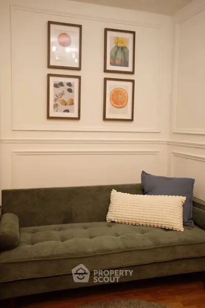 Cozy living room with stylish green sofa and framed wall art