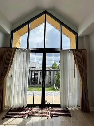 Stunning high-ceiling living room with large windows and garden view