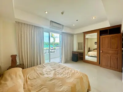 Spacious bedroom with balcony access and elegant wooden wardrobe in a serene setting.