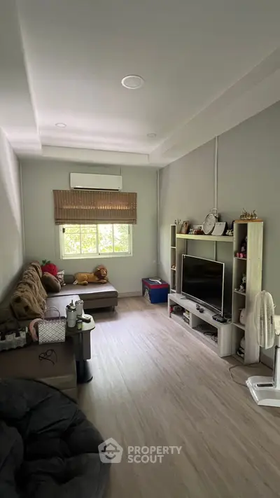 Cozy living room with modern decor and large TV unit, perfect for relaxation.