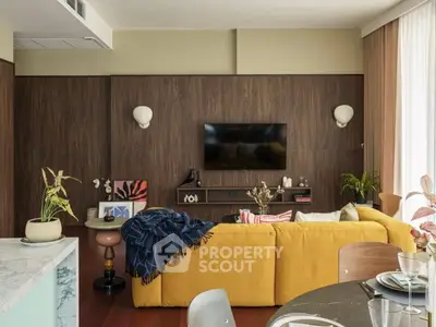 Stylish modern living room with yellow sofa, wall-mounted TV, and elegant decor.