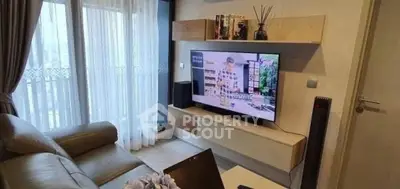 Modern living room with sleek furniture and large TV, perfect for relaxation.