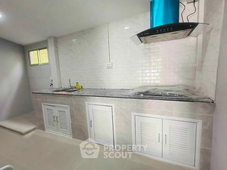 Modern kitchen with sleek countertops and stainless steel range hood
