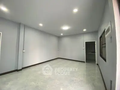 Spacious empty room with modern lighting and sleek flooring, perfect for customization.