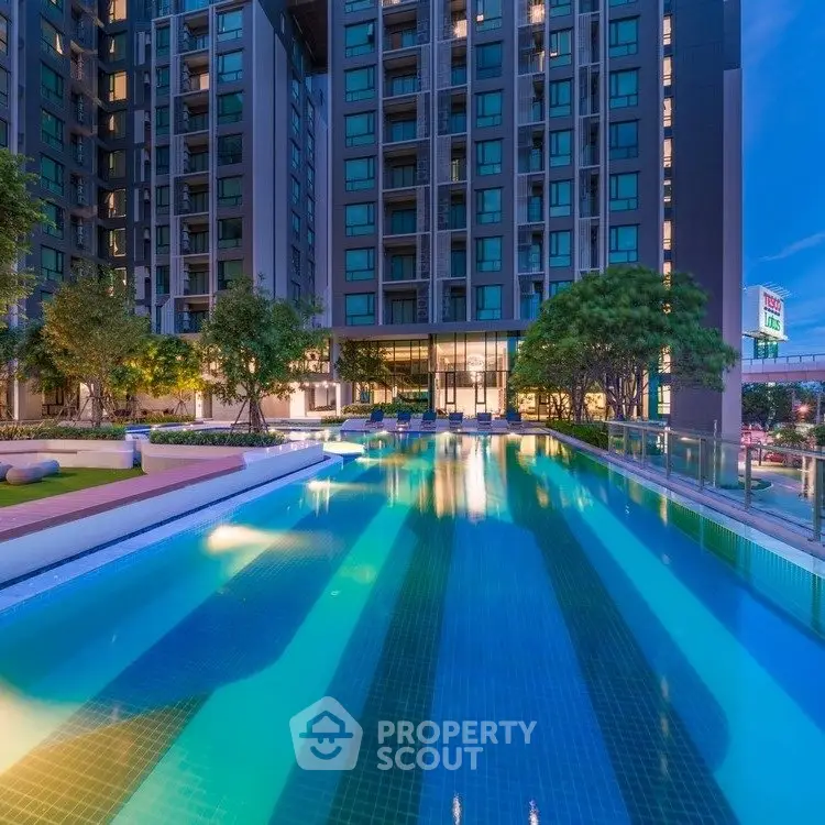 Luxurious apartment complex with stunning pool and modern architecture at dusk.