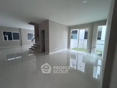 Spacious modern living room with glossy floors and large windows for natural light.