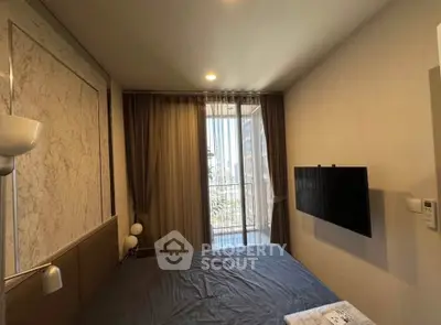 Cozy bedroom with balcony and city view, featuring modern decor and wall-mounted TV.