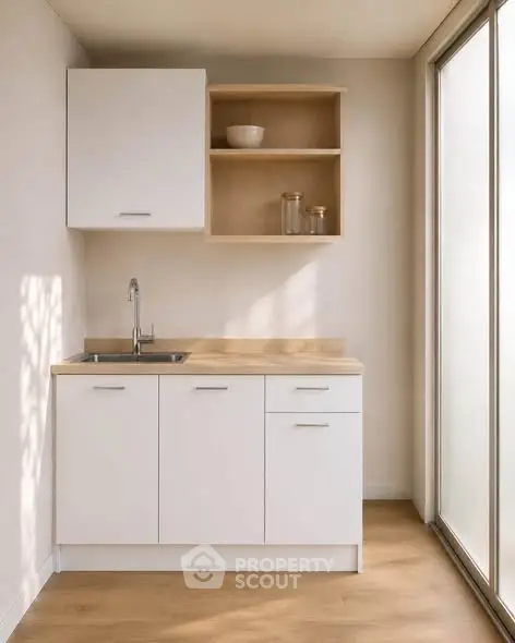 Modern minimalist kitchen with sleek white cabinets and natural light