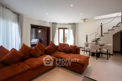 Spacious living room with plush sofa and elegant dining area in modern home