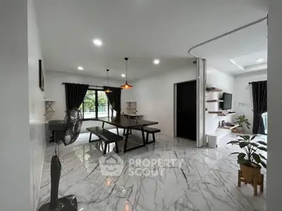 Spacious modern living room with marble flooring and elegant dining area.